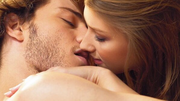 A woman kisses a man using an enhancement product